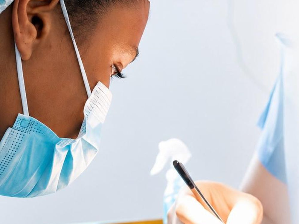 Practitioner wearing a mask, focused on the procedure, in a medical setting